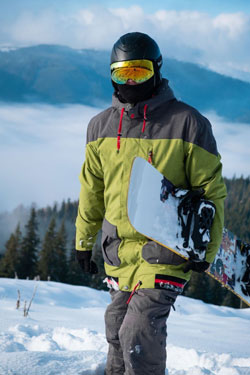 A snowboarder in the mountains wearing a jacket.